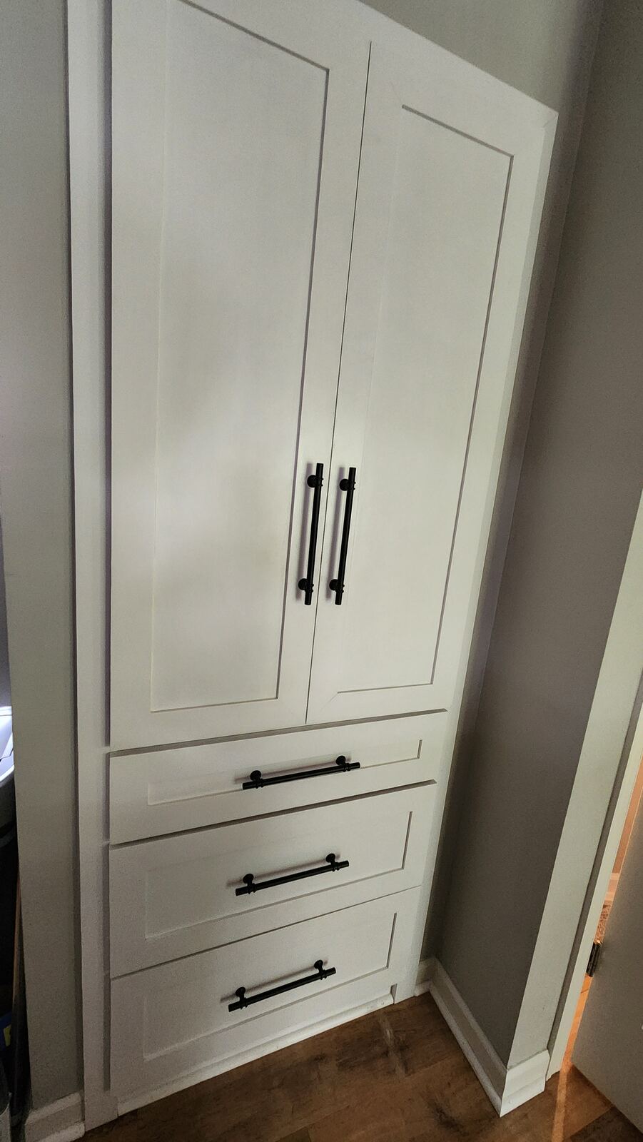 Custom white pantry cabinet with black hardware