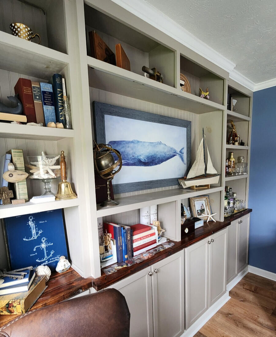 Nautical-themed built-in shelving with whale art and model ship