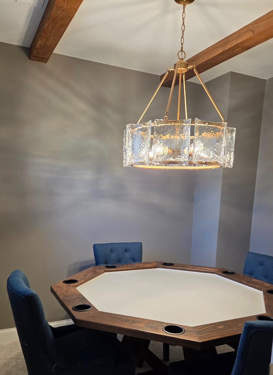 Custom octagon poker table under a brass and glass chandelier