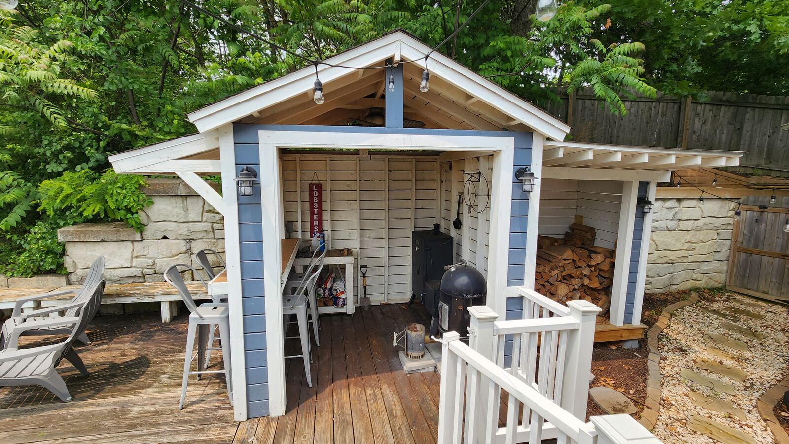 Custom outdoor bar shed with string lights and built-in bar seating